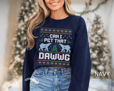 A woman wearing a navy blue sweater with a Christmas-themed design and text on it.